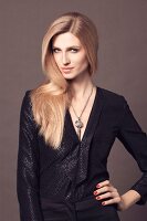 A young blonde woman wearing an elegant black blouse