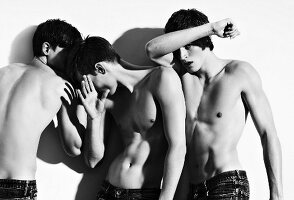 Three bare-chested young men hiding faces (black and white photo)