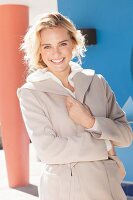 A young blonde woman wearing a beige coat