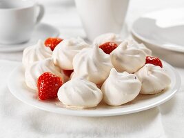Strawberry meringues on a plate with fresh strawberries