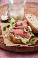 A wholemeal roll topped with roast beef, mustard and gherkins