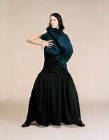 Junge Frau in langem schwarzen Kleid mit Wolltuch um Schultern