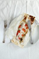 Fish with cherry tomatoes baking parchment paper