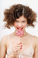 A young woman with a large lolly wearing a lace bra