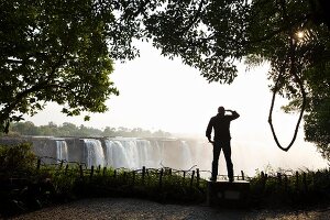 A man standing at Victoria Falls, Africa