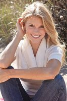 Young blonde woman wearing jeans and knitted top