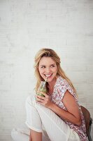 A woman drinking a green smoothie