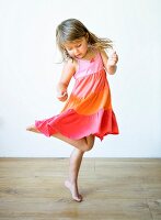 Kleines Mädchen tanzt in Volantkleid