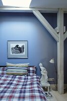 Schlafzimmer mit blauer Wand und Holzbalkenkonstruktion