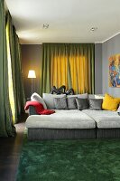 Wohnzimmer in Grau und Grün mit großem Sofa