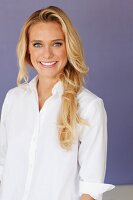 A young blonde woman wearing a white blouse
