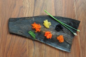 Various types of caviar on a leaf