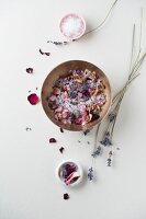 Schüssel Badesalz, getrocknete Rosenblätter und Lavendelblüten