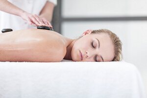 A woman having a hot stone massage in a spa