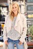 Junge blonde Frau in Grobstrickpulli und heller Fleecejacke