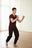 The tiger (Huxing, Qigong) – Step 3: left foot forward, fingers in claws at chest