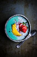 Spirulina-Chia-Pudding mit Pfirsich, Erdbeeren und Kokosraspeln