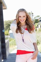 A young dark blonde woman wearing a light shirt and fabric trousers