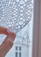 Transparenter Klebehaken an Fenster für gehäkeltem Vorhang