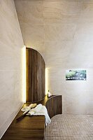 A designer bathroom with a bench and a semi-circular panel under a tiled roof slope