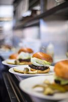 A row of burgers lined up ready to serve in a restaurant