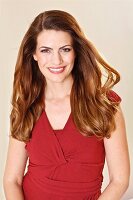 A smiling brunette woman in a red summer dress