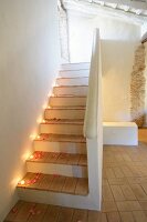 Mit Teelichtern und Rosenblütenblättern romantisch dekorierte Treppe in restauriertem historischem Gebäude