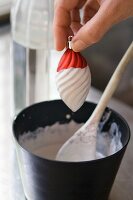 Dipping a Christmas-tree bauble in plaster