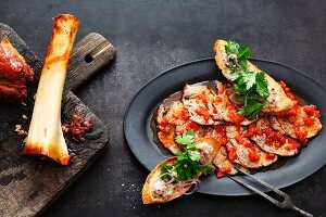 Slices of the year shank in a red pepper marinade served with crostini with veal bone marrow