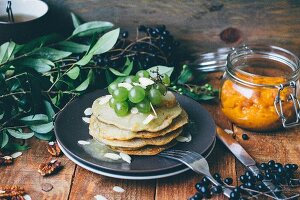 Stacked pancakes with grapes and almond flakes