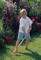 Child raking up grass cuttings