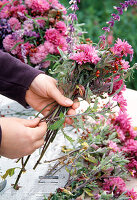 Strauß binden mit Herbstchrysanthemen, Hagebutten und Salbei. 3. Step