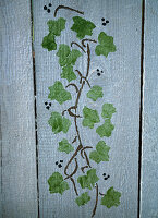 Painting a wooden wall with ivy using a stencil