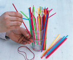 Carnations in a glass with coloured straws (1/3)