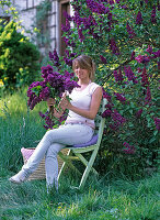 Syringa 'Charles Joly' (Lilac) - Young woman with bouquet of lilacs