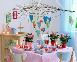 Table decoration with roses (pot rose), cake in heart shape