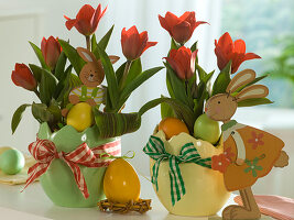 Tulipa 'Showwinner' (tulips) with wooden rabbits and Easter eggs in Easter planters