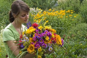 Woman with bouquet of Erigeron, Heliopsis