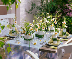 Table decoration with daisies in small bottles