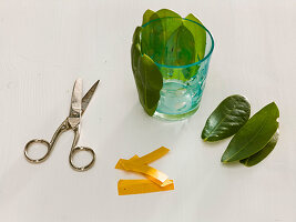 Dahlia flowers in glasses with rhododendron leaves (3/6)