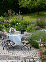 Seating area with laid table on paved terrace