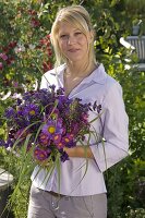 Young woman with bouquet of Callistephus (Summer Aster), Erigeron