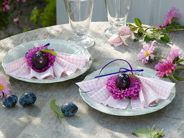 Serviettendeko aus pinken Sommerastern-Blüten mit Zwetschgen