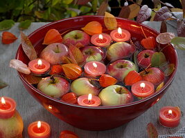 Red swimming bowl with apples and candles