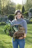 Young woman holding wicker basket with vegetables