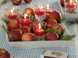 Vorweihnachtliche Dekoration mit Schwimmkerzen in Gläsern auf Tablett