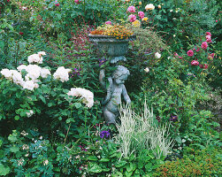 Bronzestatue neben der Englischen Rose 'Redoute', Rosa 'Magenta', Rosa 'Charlotte'