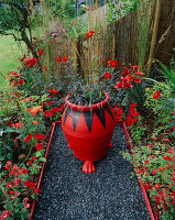 Der rote Garten mit schwarzem Glaskies, rot-schwarzem Topf mit Ophiopogon planiscapus 'Nigrescens', roten Lilien, Dahlie 'Bishop of Llandaff' und Achillea 'Fanal'
