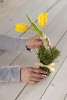 Table decoration with yellow tulips and blueberry branches