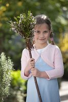 Girl with palm bouquets made of Buxus (box) and Salix